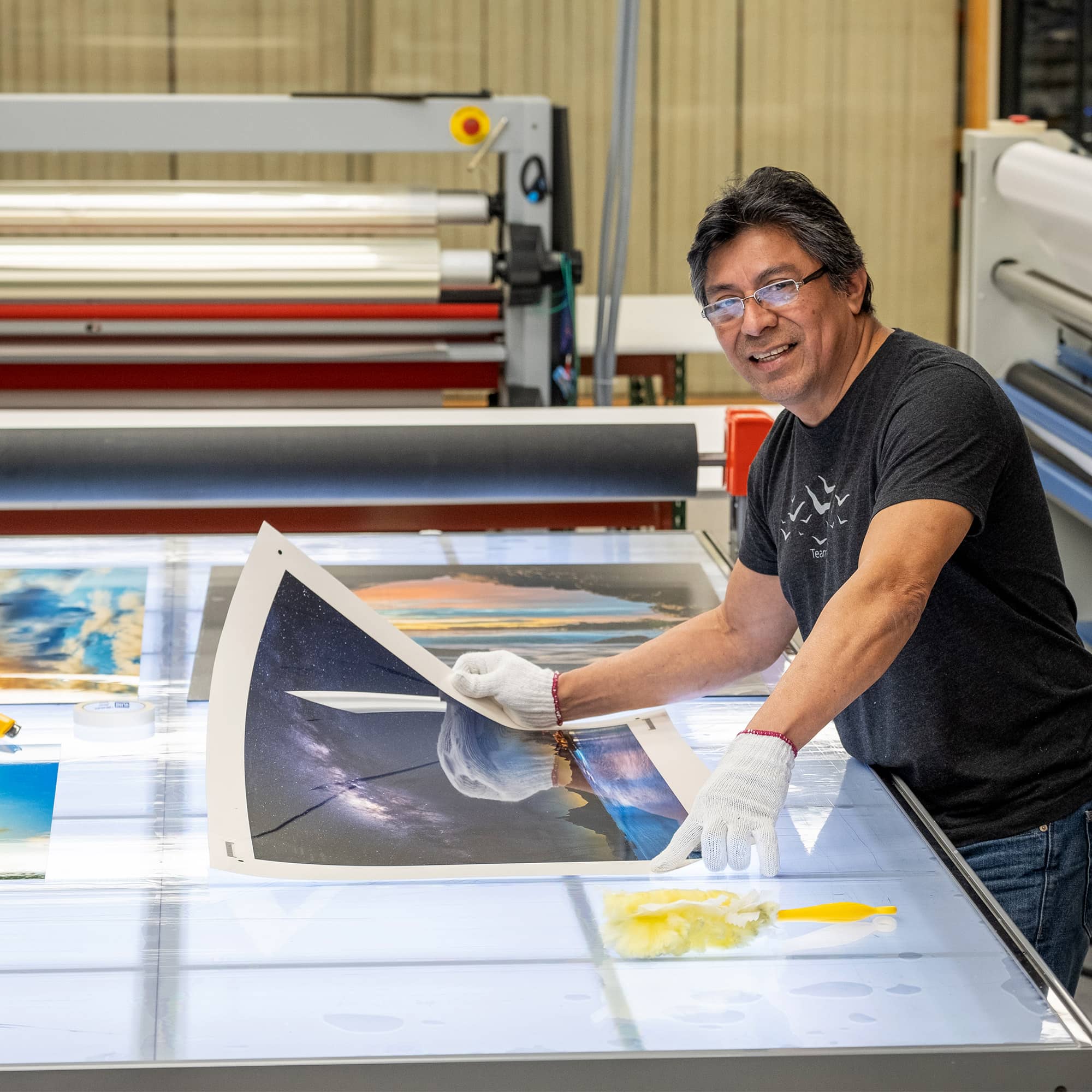 A worker looks at a metal print