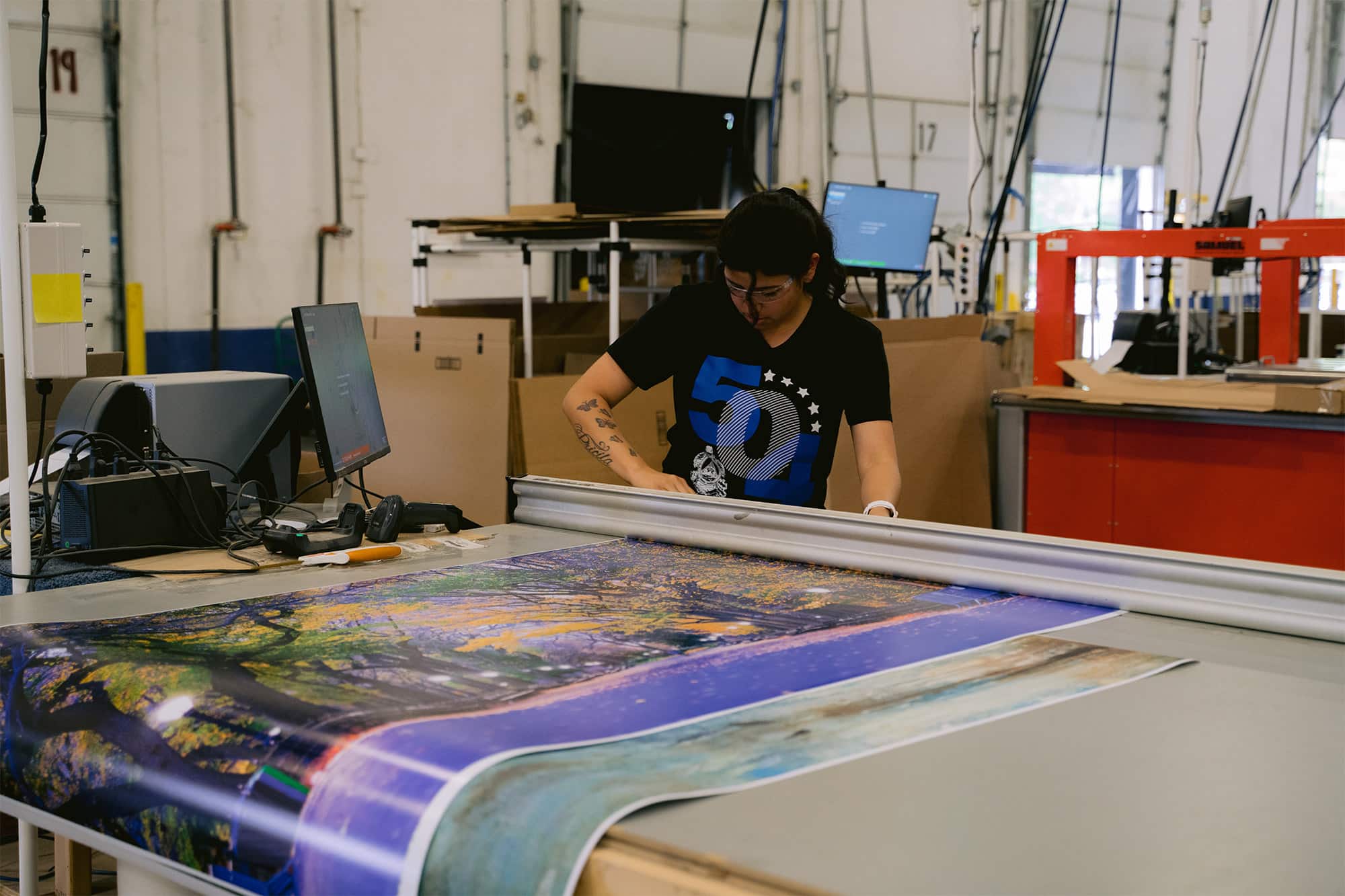 Reducing Factory Overhead Costs | Sensaria person cutting a poster print